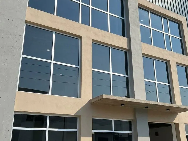 Frente de vidrio templado en edificio comercial de tres pisos